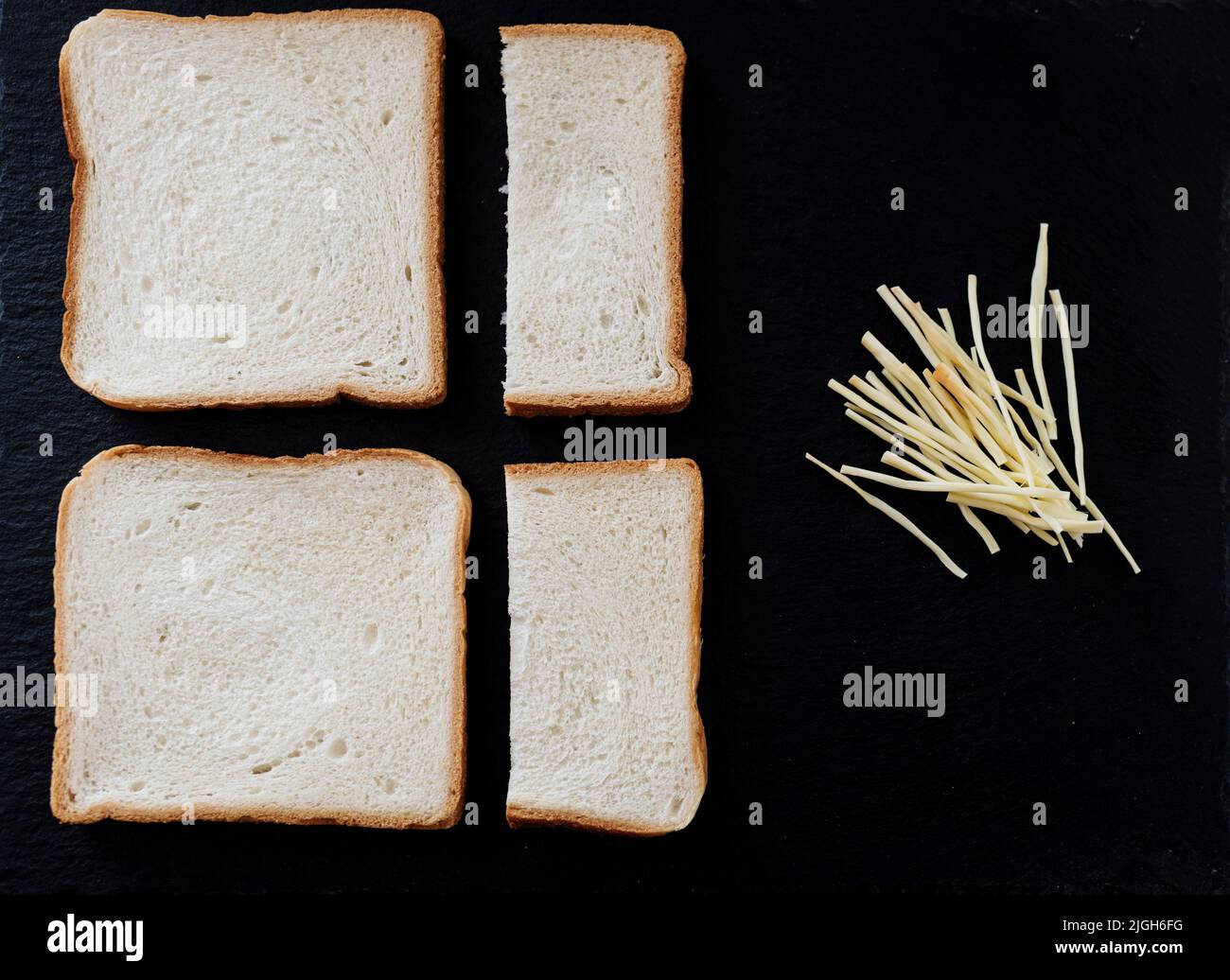Slice of white bread and cheese on black board. bread for toast Stock