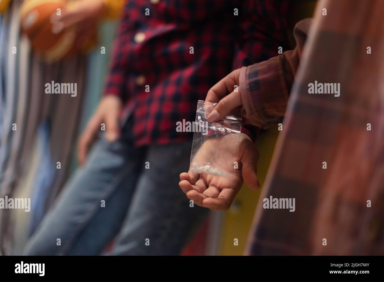 Unrecognizable high school students dealing drugs in shool corridor. Stock Photo