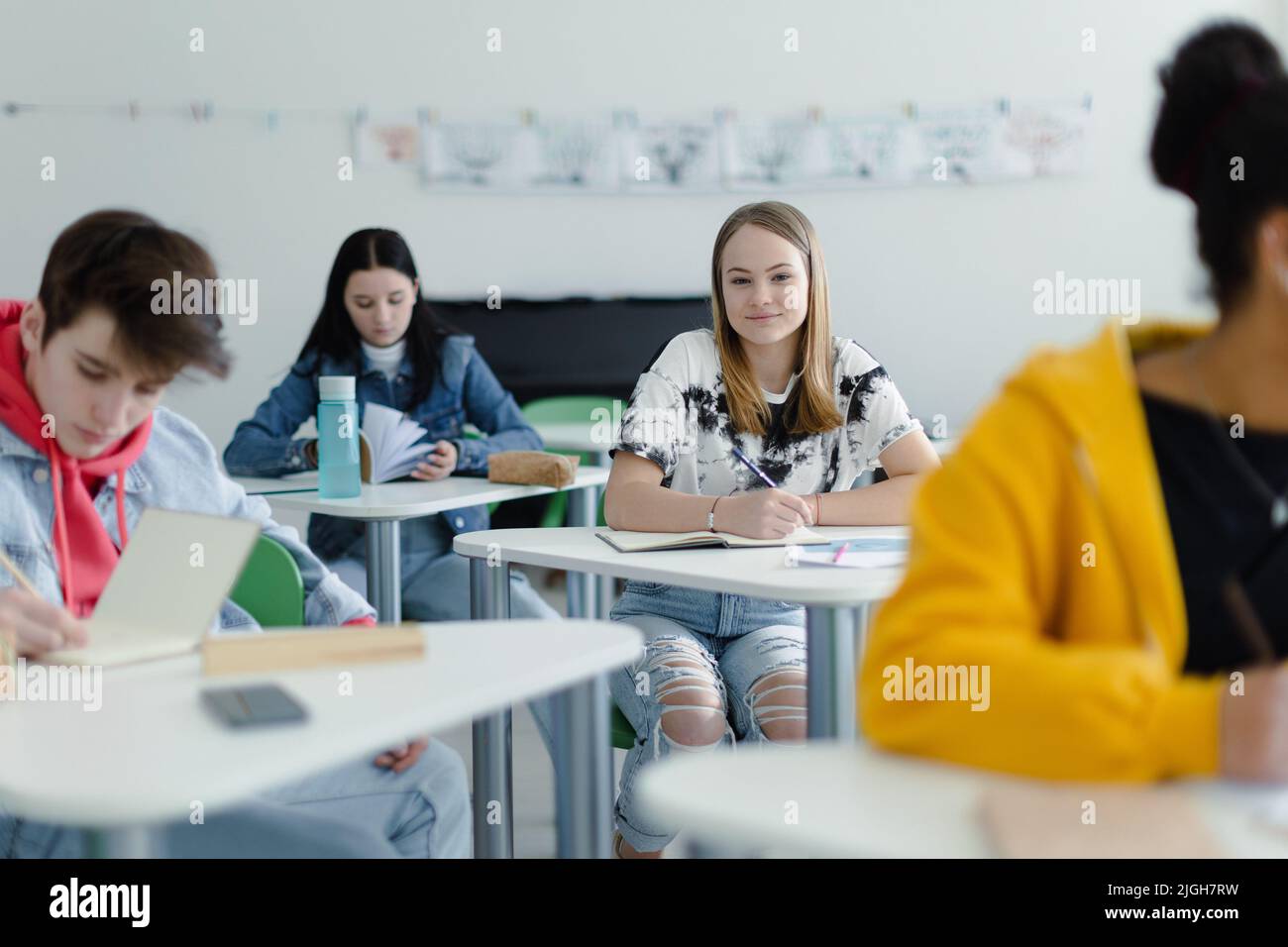 High school students paying attention in class, sitting in their desks ...