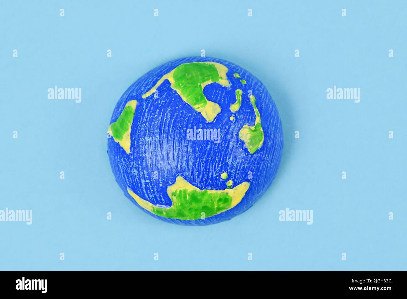 Small planet earth model on blue background Stock Photo