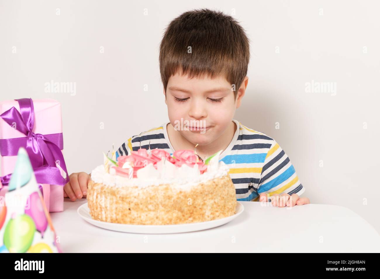 The birthday boy blows out the candles on the birthday cake Stock Photo