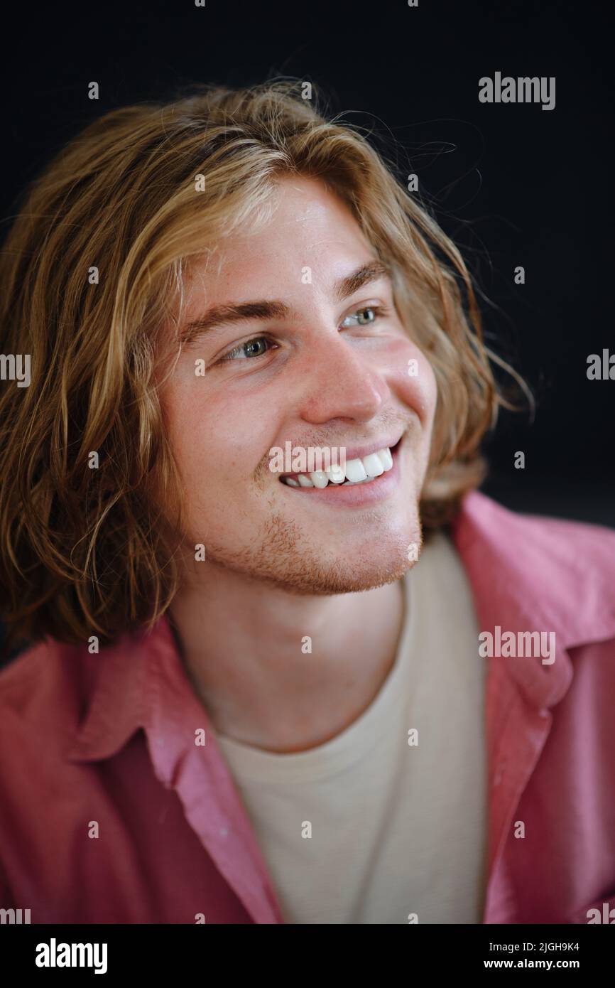 Portrait of confident handsome young man looking away on black background, close-up Stock Photo