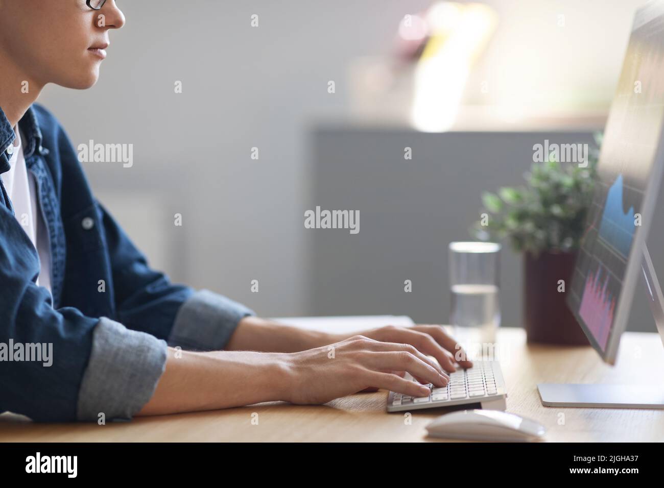 Young Man Trading Online, Checking Financial Statistics While Working On Computer Stock Photo