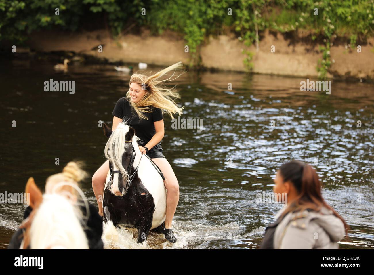 A young woman riding her horse in the River Eden, Appleby Horse Fair, Appleby in Westmorland, Cumbria Stock Photo