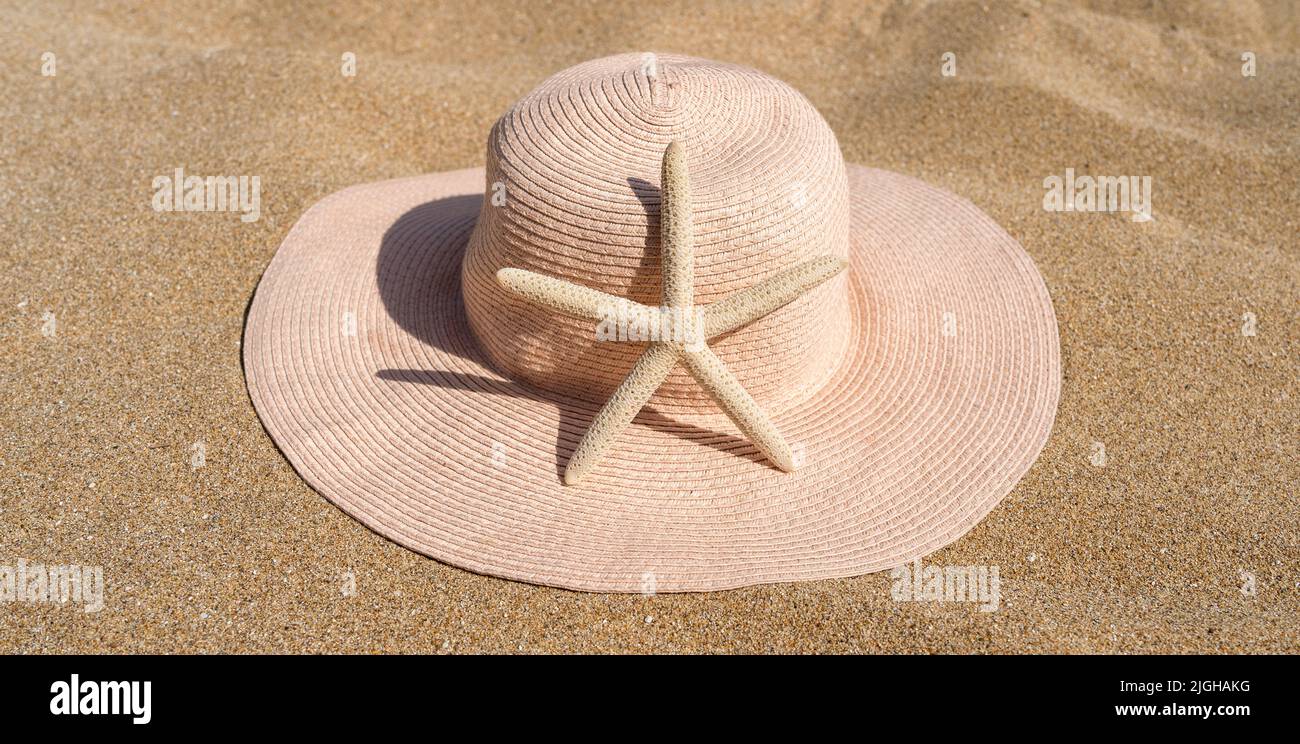 Starfish with straw hat on beautiful sandy beach in the Mediterranean Stock Photo