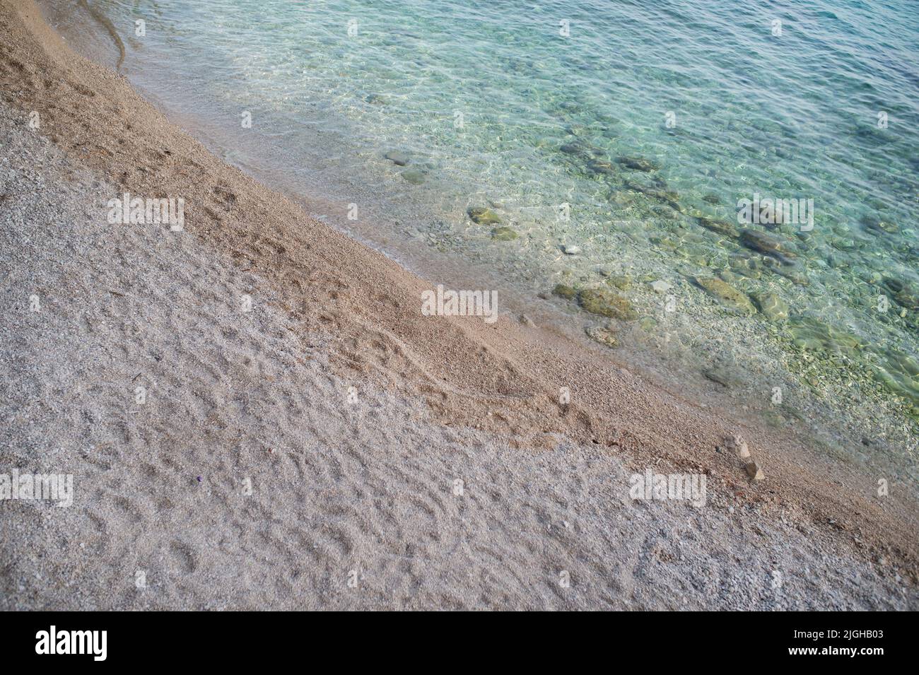 Soft blue ocean wave on clean sandy beach, background Stock Photo