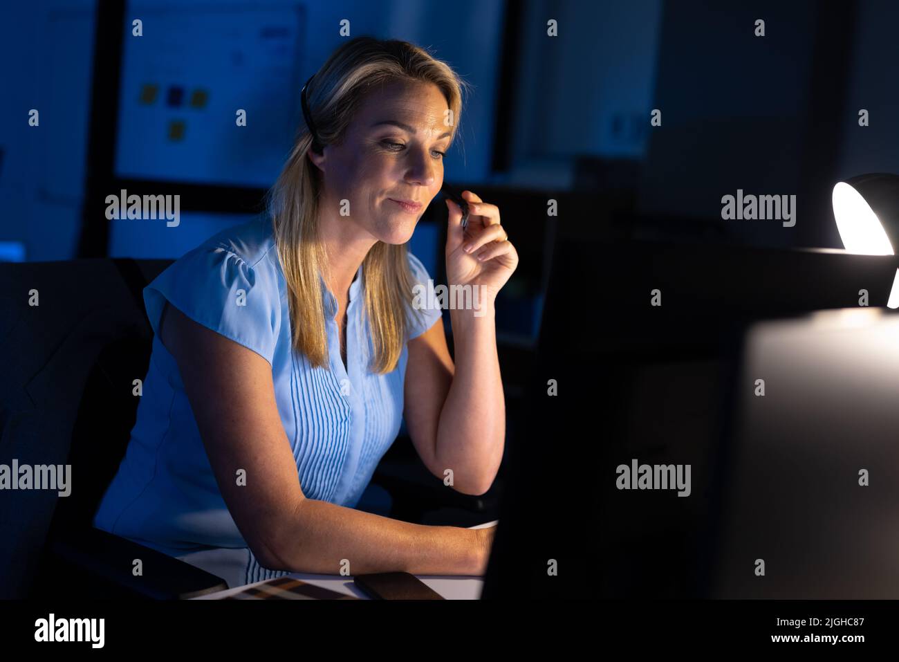 Caucasian female customer service representative talking with customer over headset in office Stock Photo
