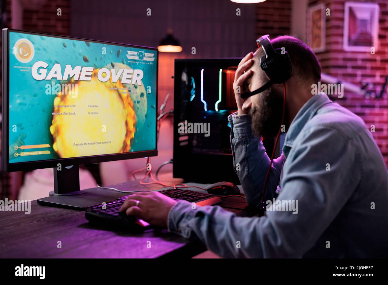 Sad male streamer losing action video games championship with multiple players on internet. Modern gamer streaming gameplay and feeling frustrated about lost gaming tournament. Stock Photo