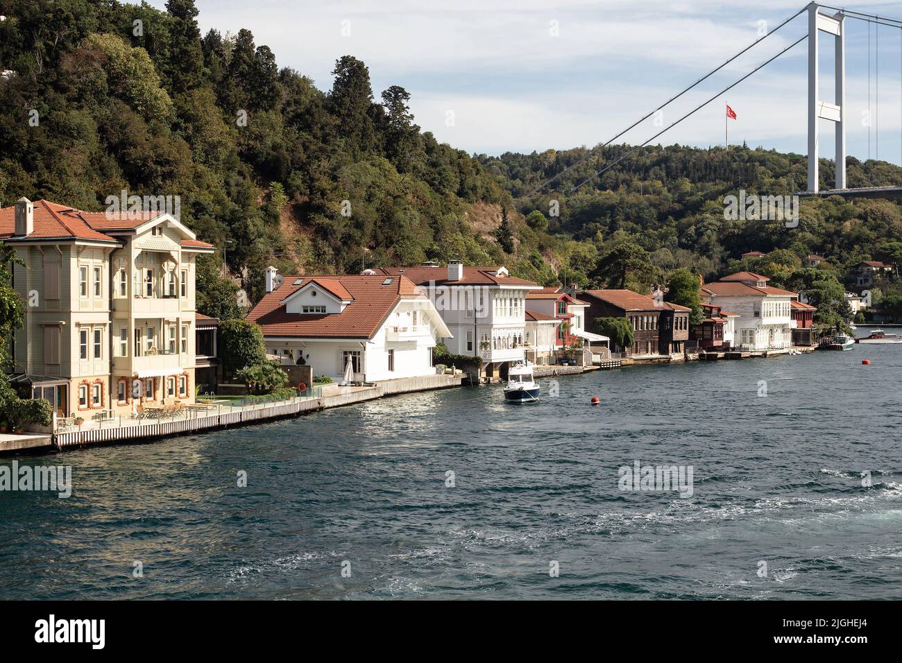 View of a small fishing boat, historical and traditional mansions by Bosphorus in Kanlica area of Asian side of Istanbul. It is a sunny summer day. Be Stock Photo