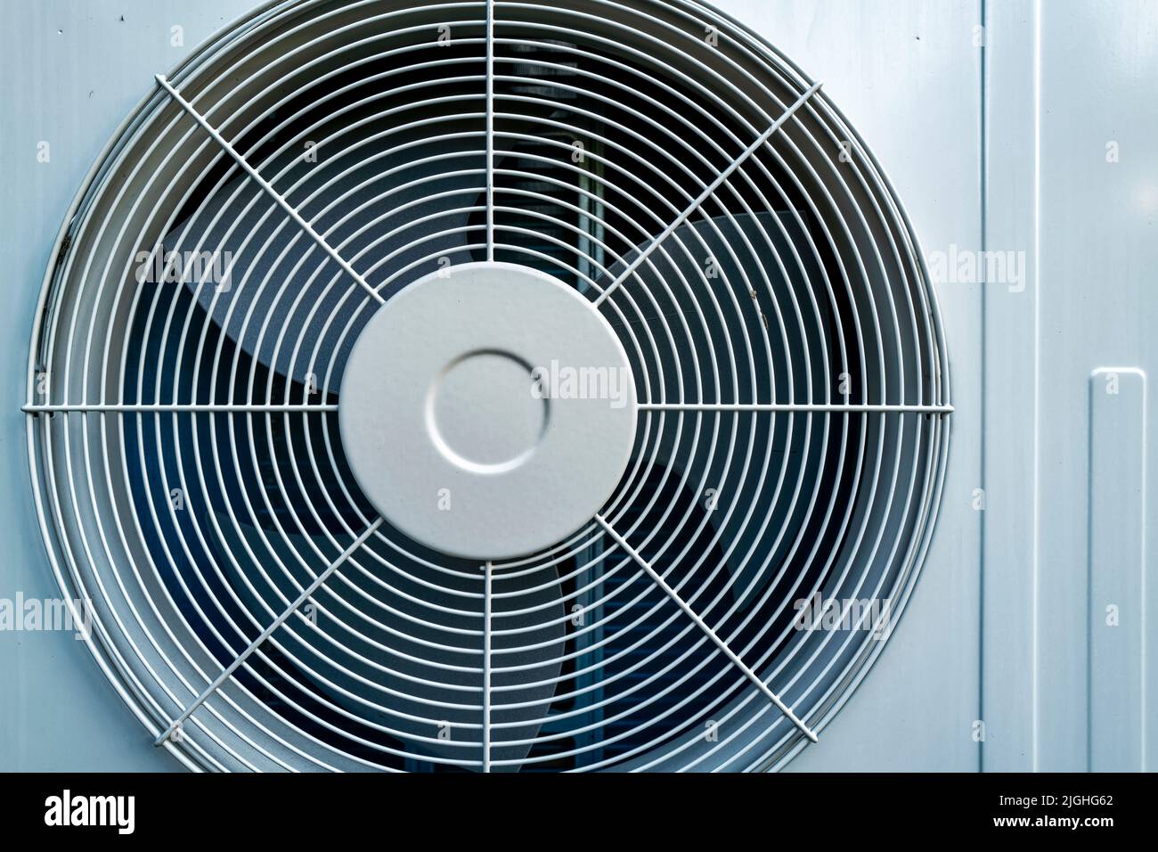 Air conditioner compressor fan mounted on an exterior wall Stock Photo
