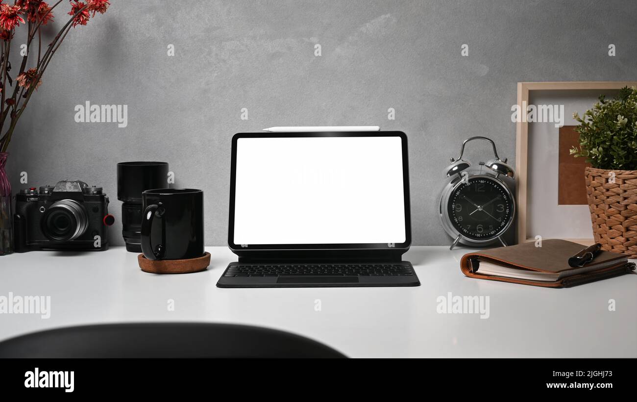 Digital table with wireless keyboard, camera, coffee cup and picture ...