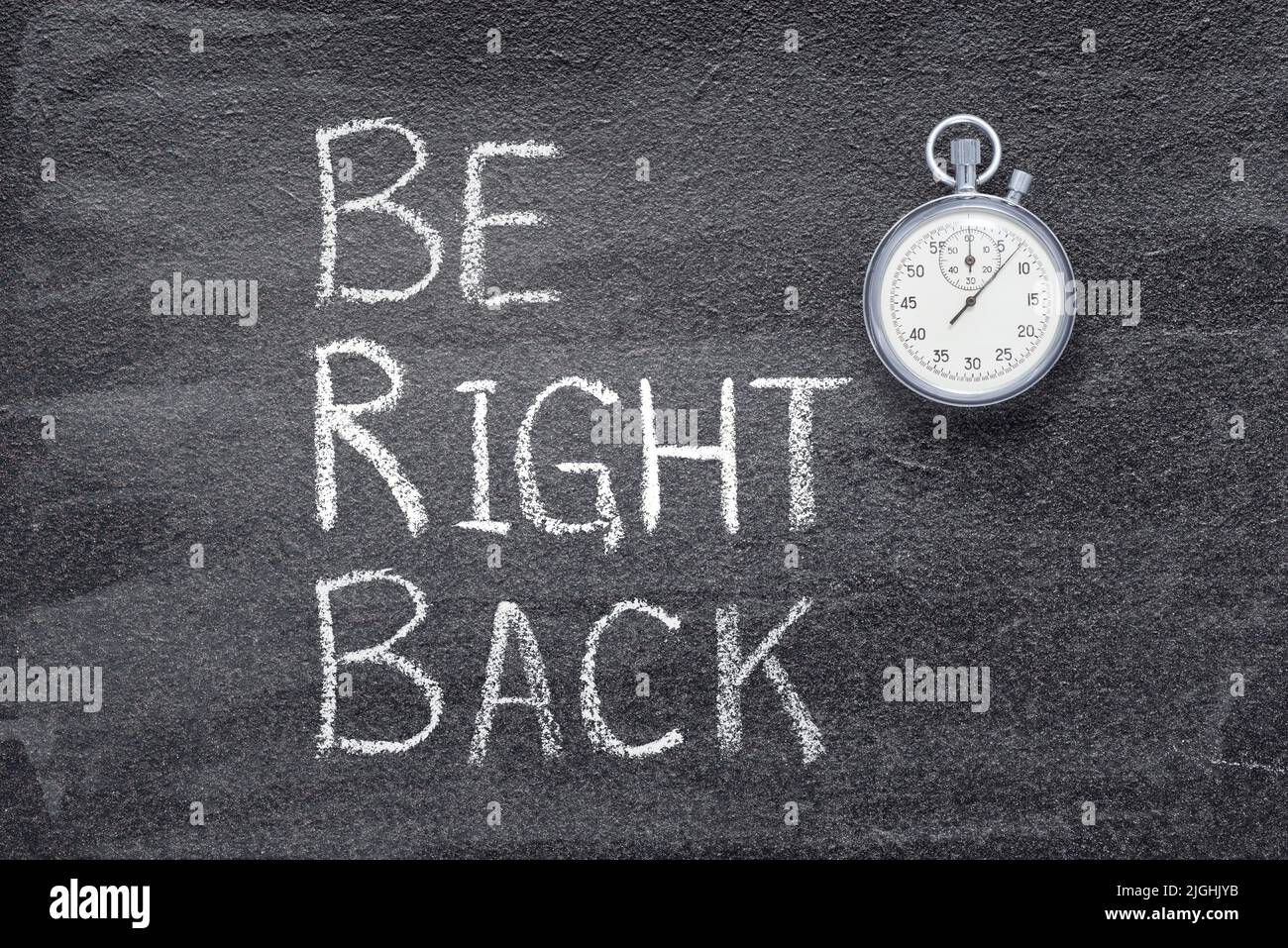 be right back phrase written on chalkboard with vintage precise stopwatch Stock Photo