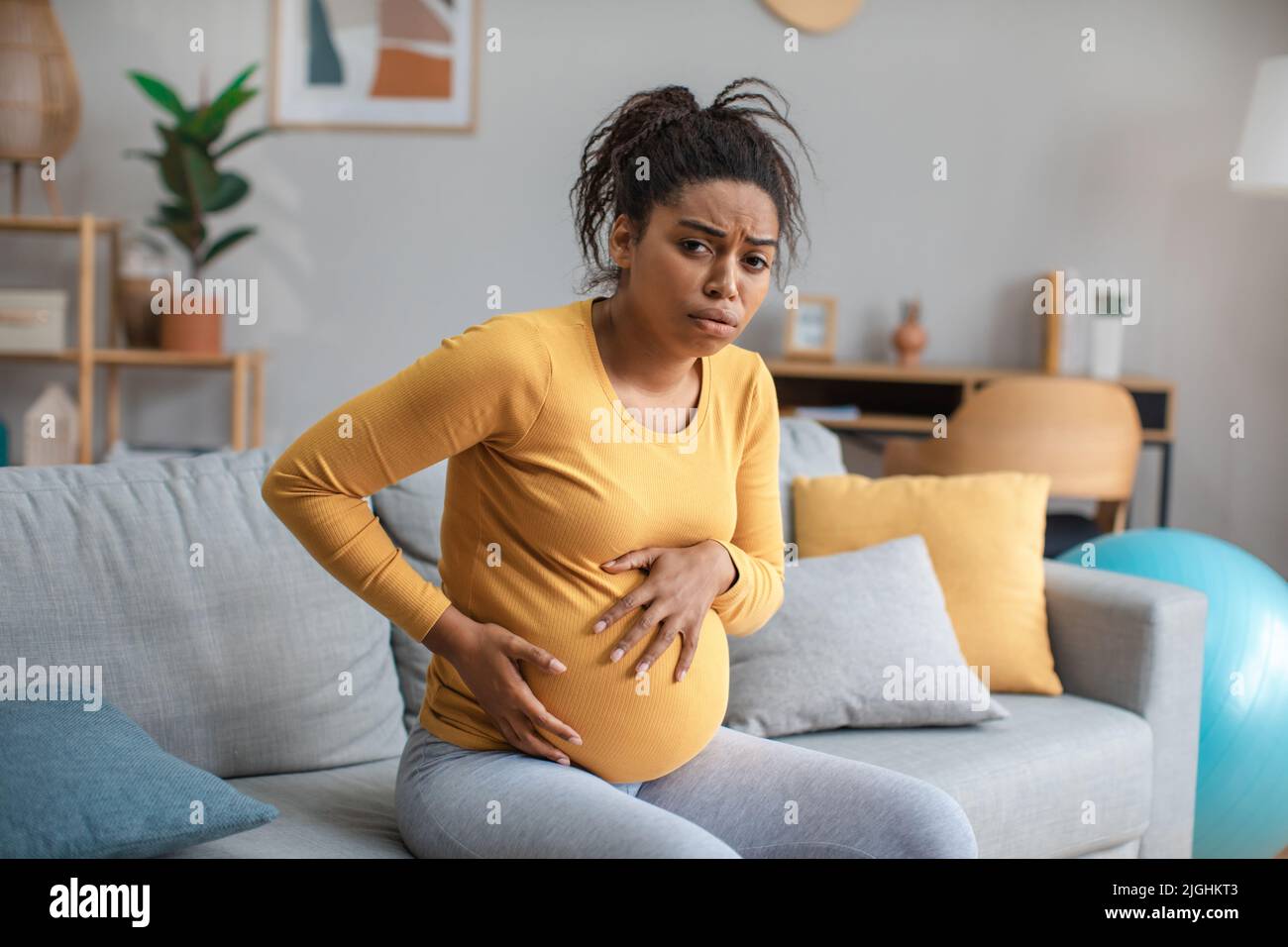 Despaired unhappy young pregnant african american female with big belly