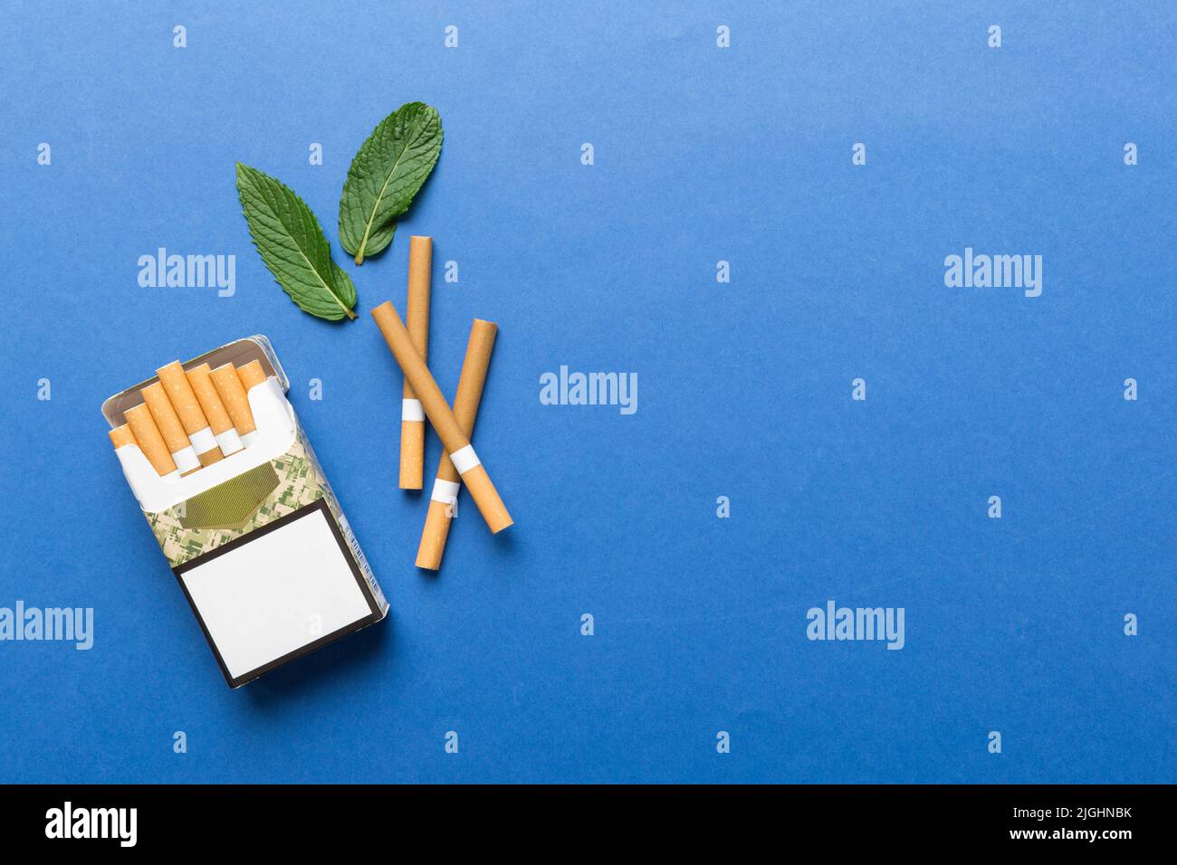 Pack of menthol cigarettes and fresh mint on colored table, Menthol