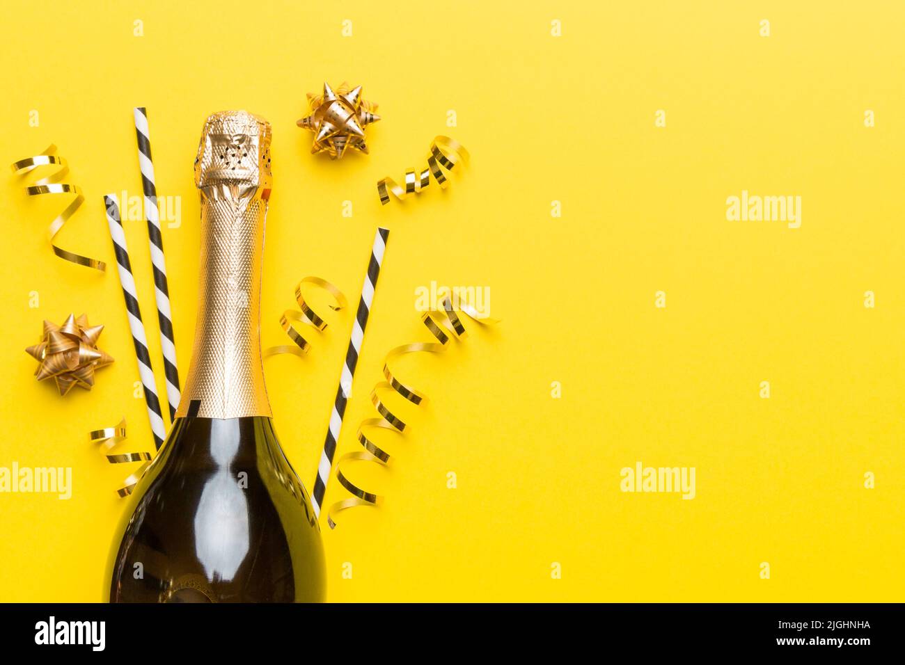bottle of champagne with glasses and colorful confetti on colored