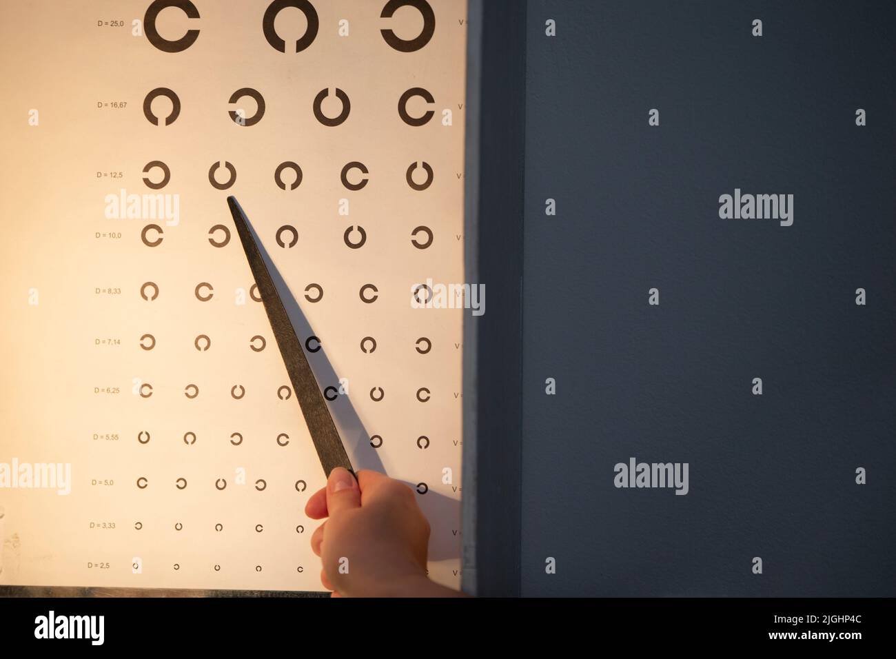 A hand with a pointer, an eye chart that can be used to measure visual