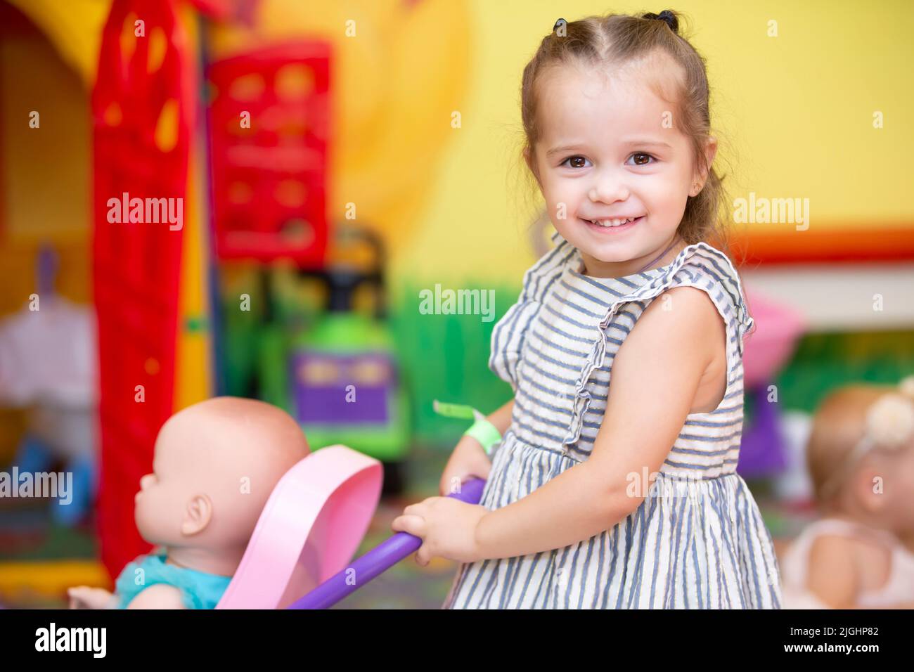 Little girl plays with a doll and smiles Stock Photo - Alamy