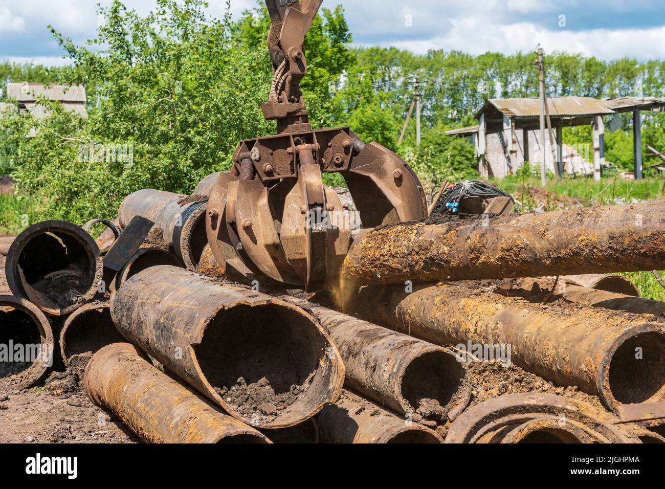 Loadermanipulator grabs heavy old castiron pipes with scrap metal