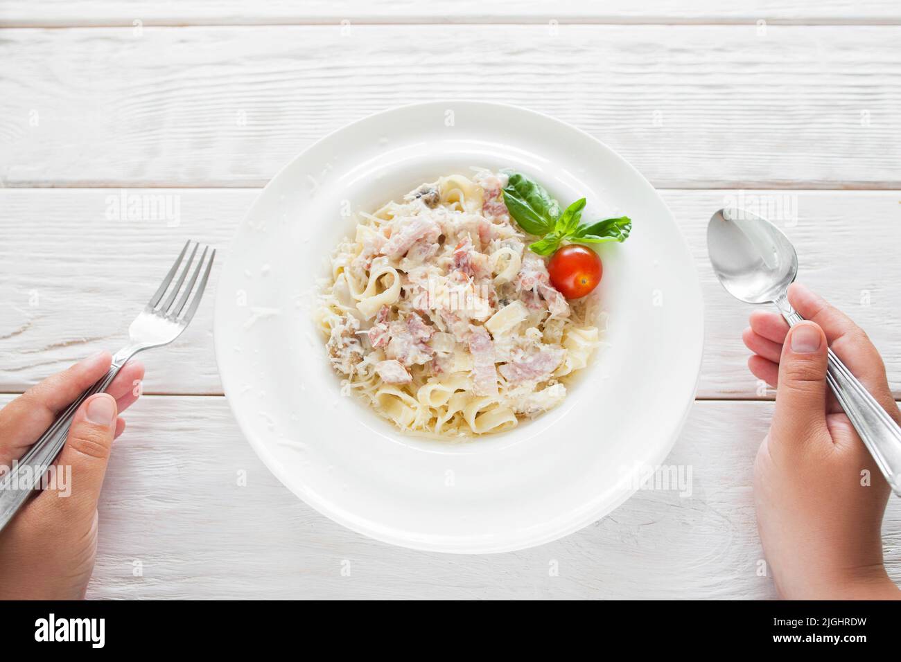 Spaghetti carbonara eating, eater pov, flat lay Stock Photo