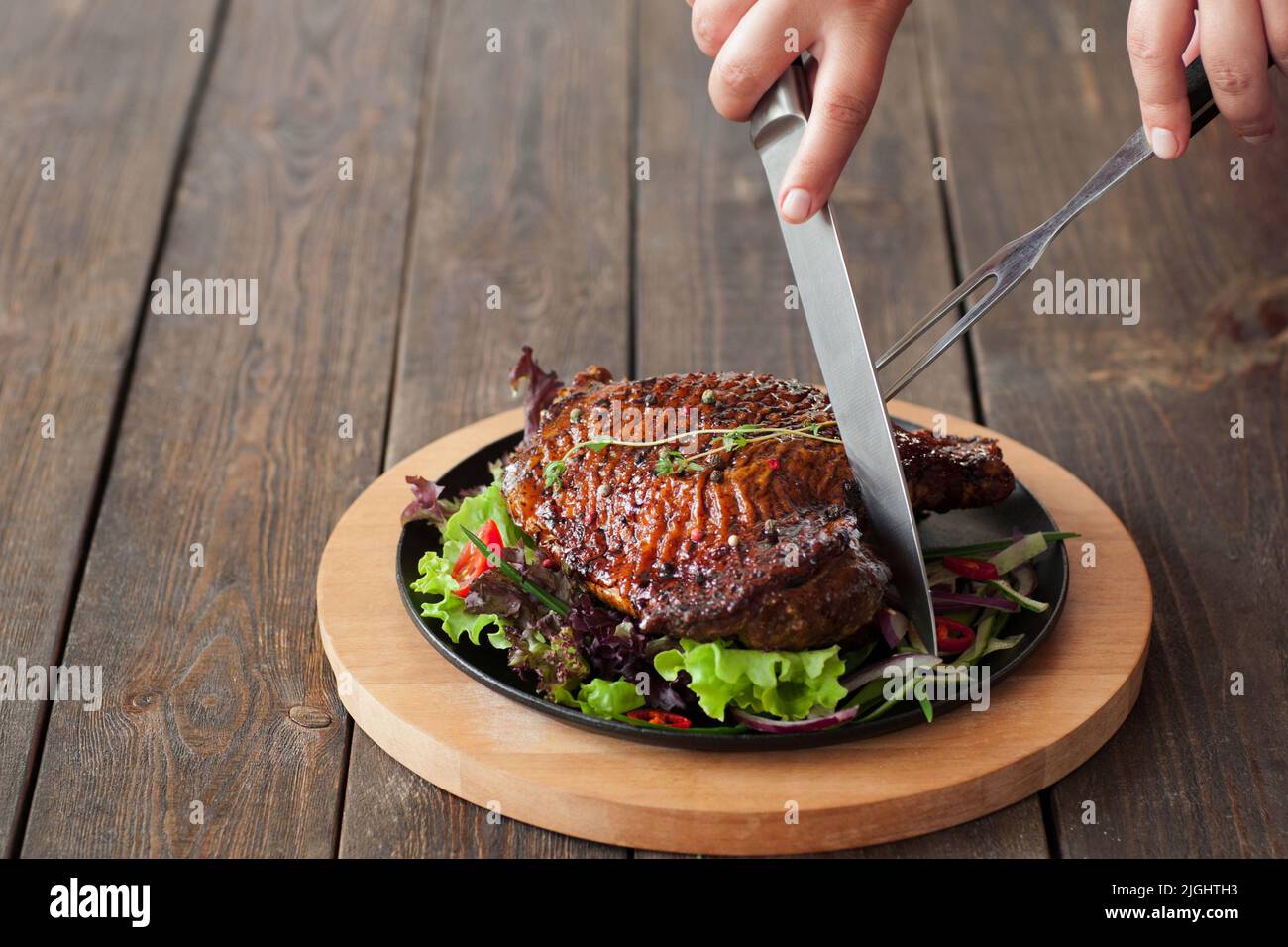 https://c8.alamy.com/comp/2JGHTH3/grilled-duck-thigh-cutting-with-cutlery-on-wooden-background-eating-at-restaurant-concept-front-view-2JGHTH3.jpg
