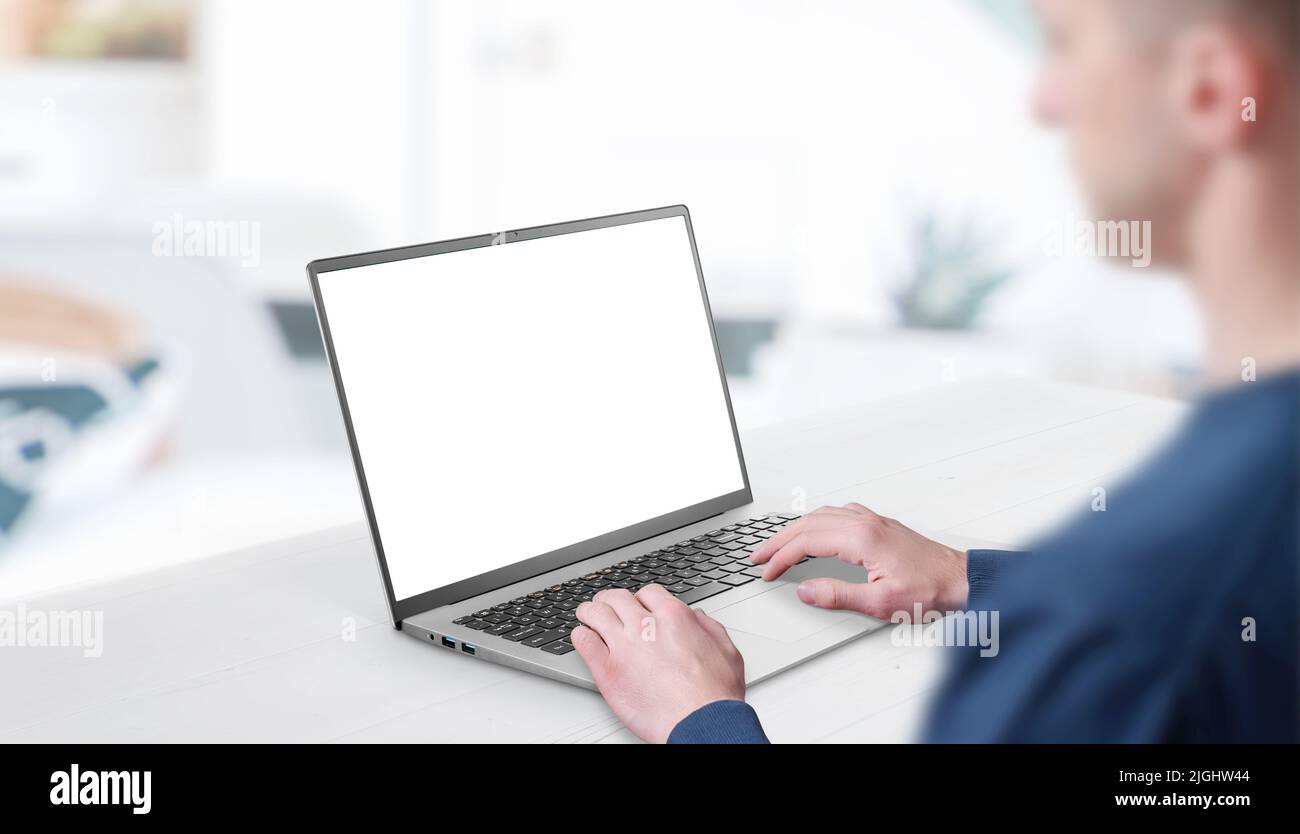 Mockup image of a man working at the laptop. Clean desk with office interior in background. Isolated screen in white for web page promotion Stock Photo