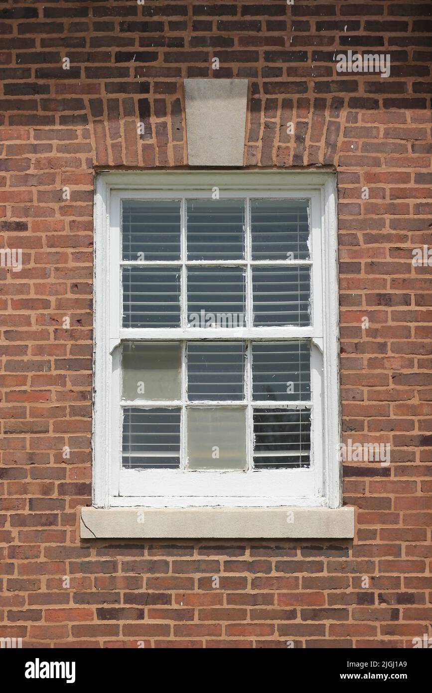 Traditional wooden frame window on a brick wall. Stock Photo