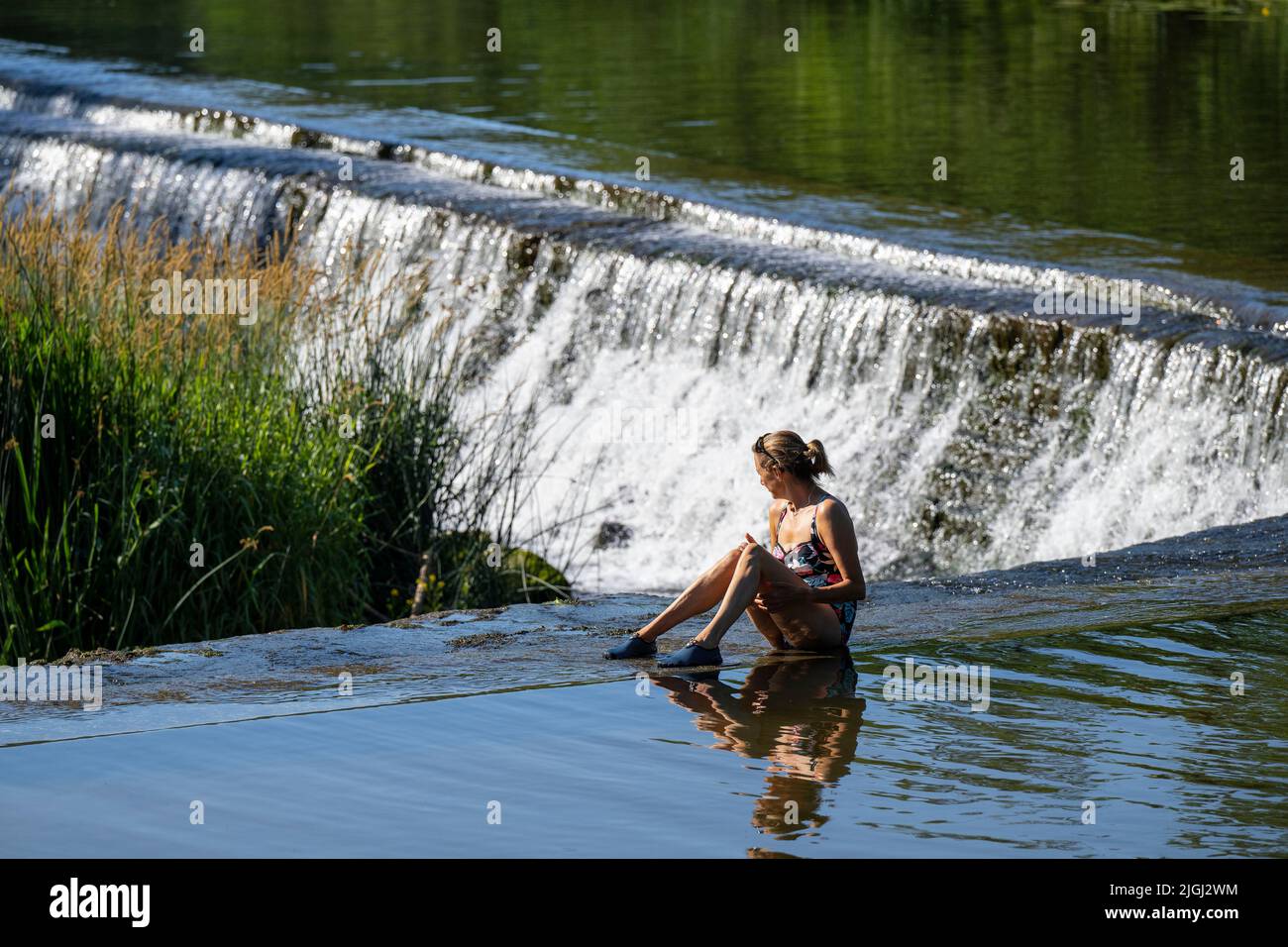 People cool off in the river Avon at Warleigh Weir near Bath in Somerset as temperatures continue to soar across the United Kingdom. Stock Photo