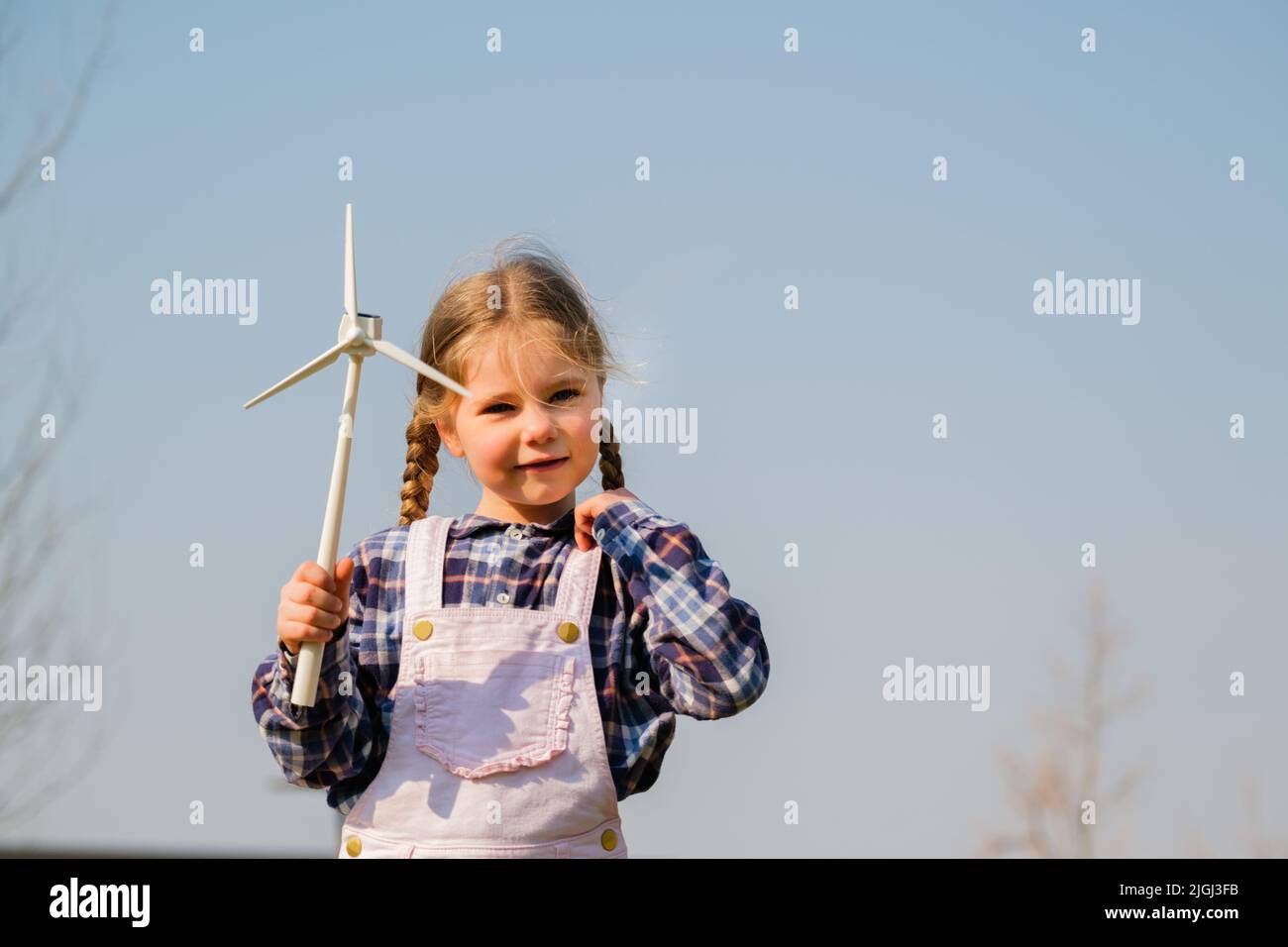 Child Playing And Looks Interested At A Wind Turbine Toy - Concept Of ...