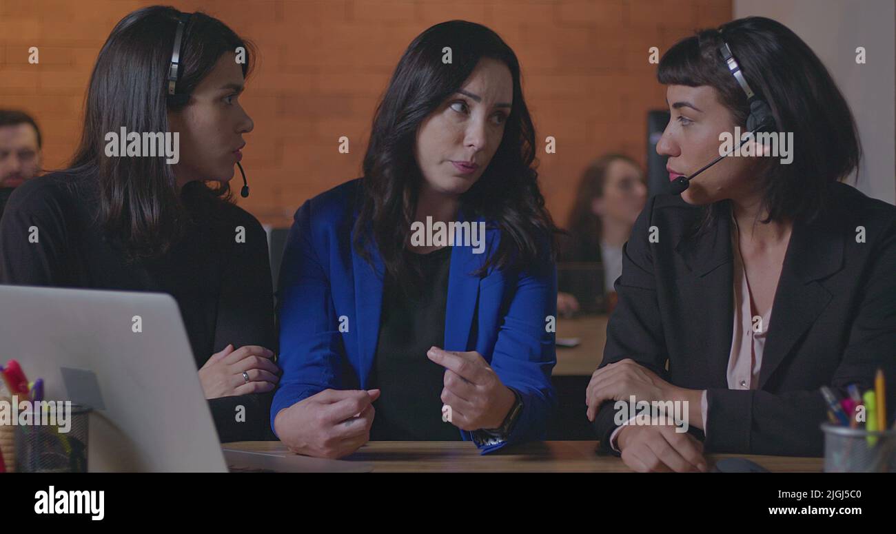 Business woman coaching younger staff in front of computer laptop