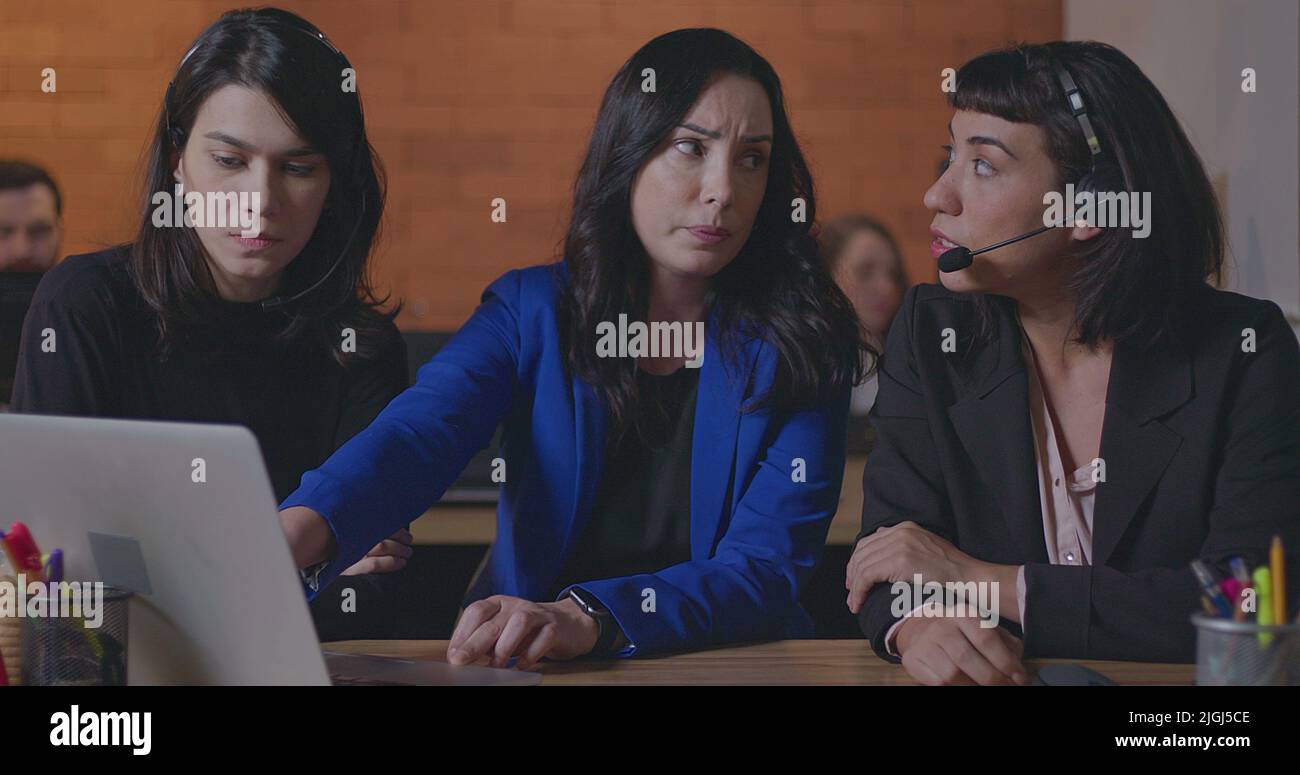Business woman coaching younger staff in front of computer laptop