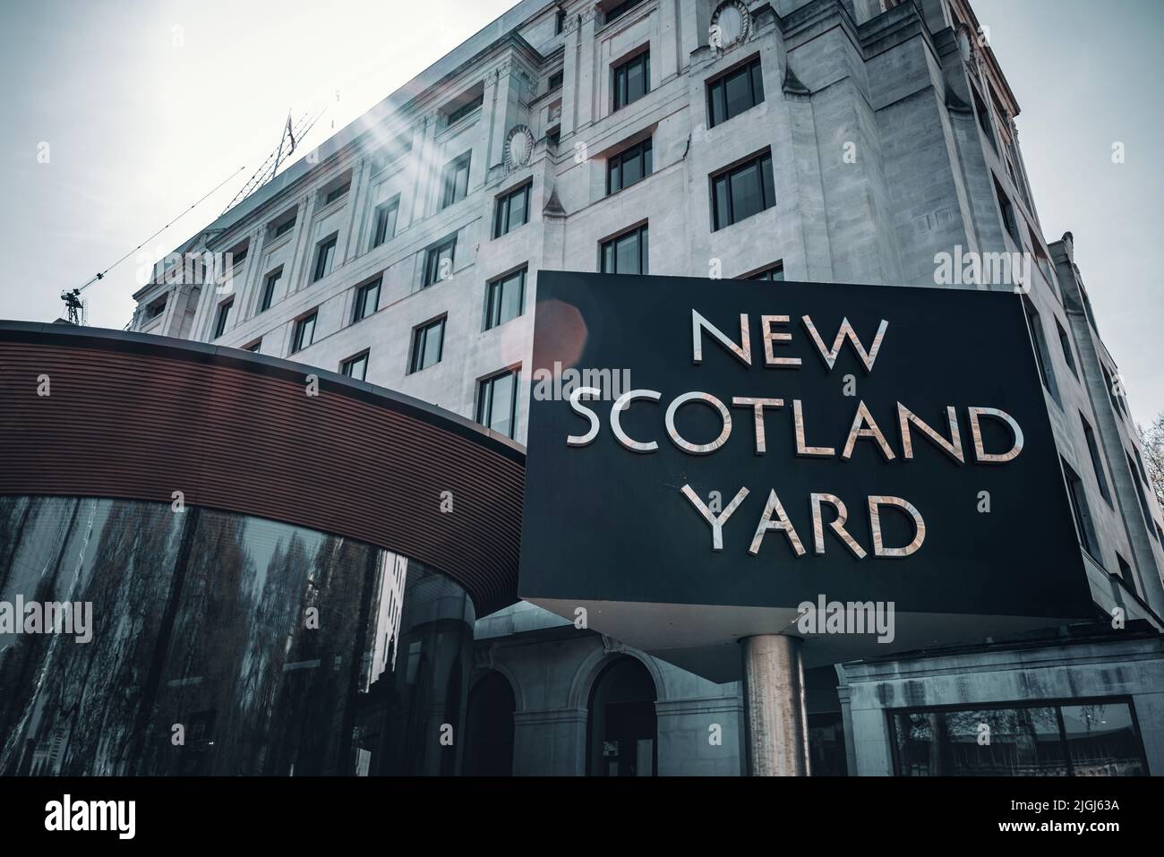 London, UK - 16th April 2022: New Scotland Yard with the iconic sign outside, London UK. Natural sun flare, retro style  filter applied. Stock Photo