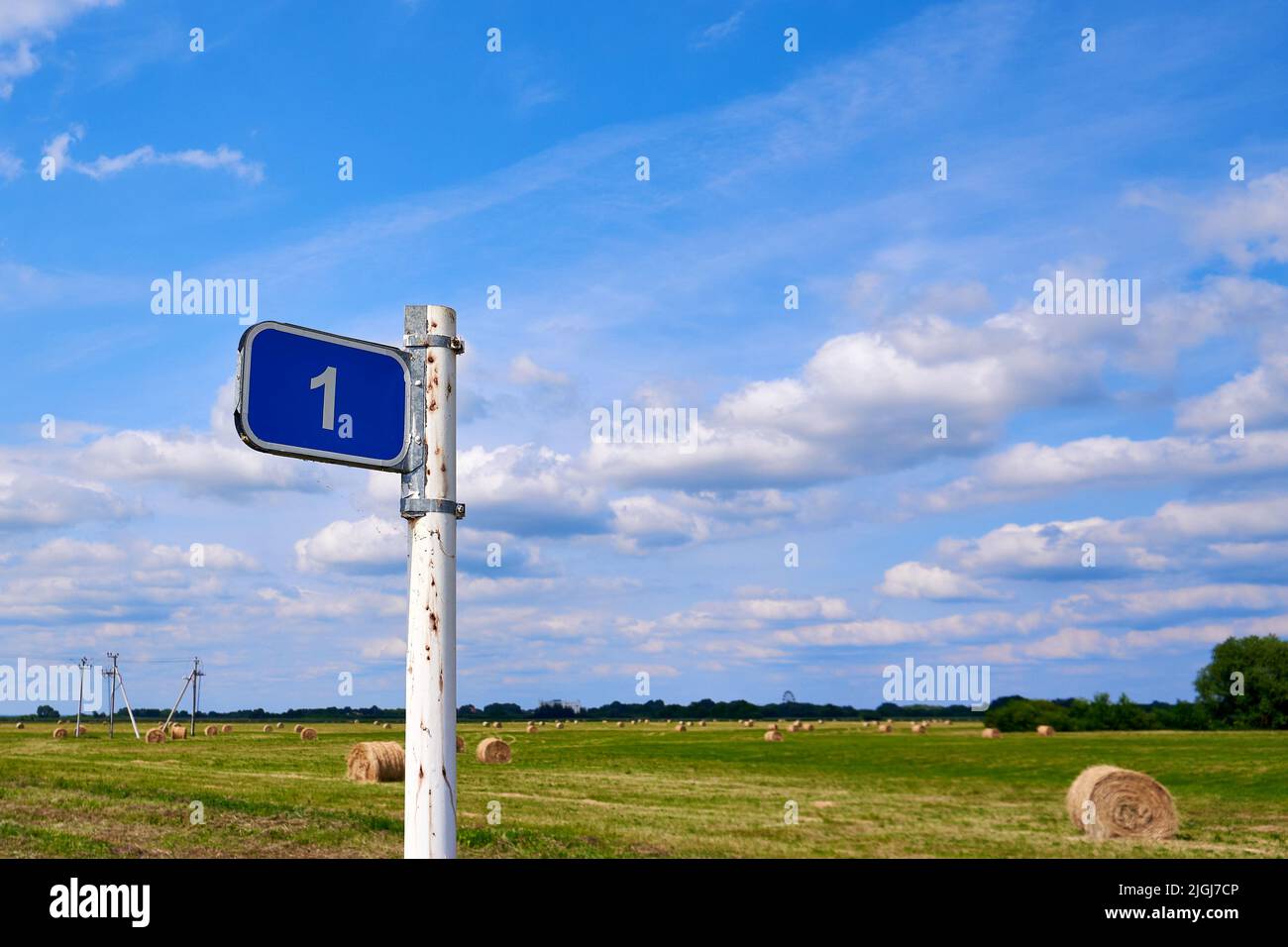 Distance road sign. Sign 1 kilometer against the blue sky and summer field Stock Photo