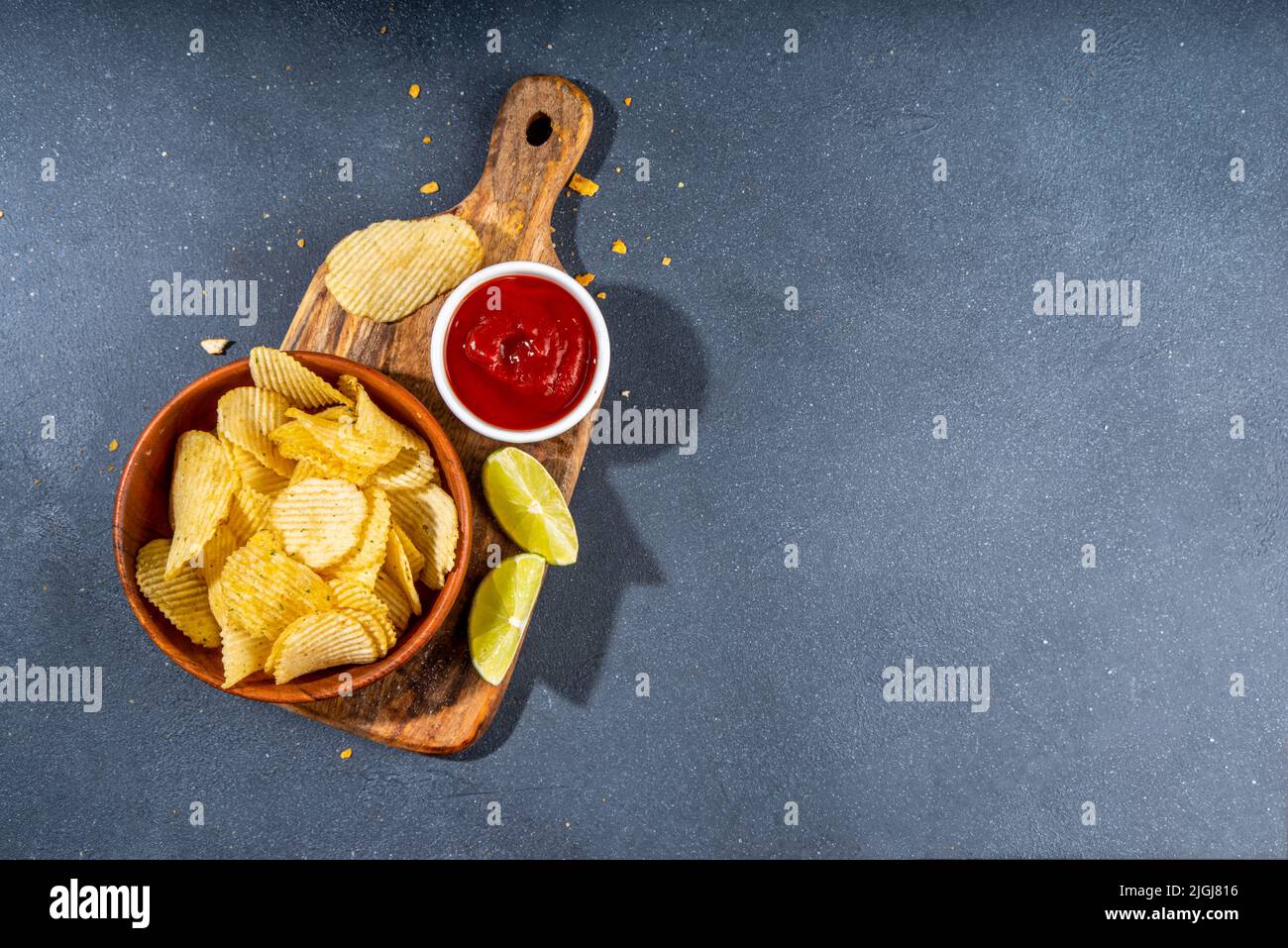 Various unhealthy salty bar snacks set. Dark grey table background with