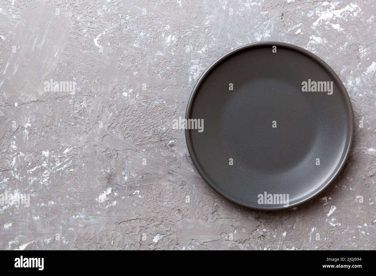 Top view of black plate on cement background. Empty space for your ...