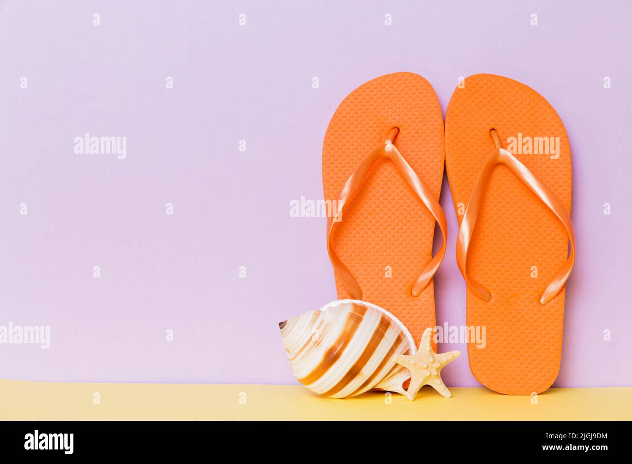 Beach accessories. Flip flops and starfish on colored background. Mock ...