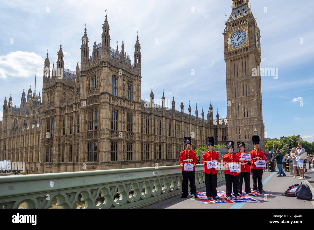 London, UK.  11 July 2022.  Members of PETA (People for the Ethical Treatment of Animals) stage a stunt on Westminster Bridge dressed as Queen’s Guards covering themselves in fake blood.  The stunt is ahead of a debate in Parliament in which MPs will discuss replacing the bearskins used for the Queen’s Guard’s caps with faux fur.  Credit: Stephen Chung / Alamy Live News Stock Photo