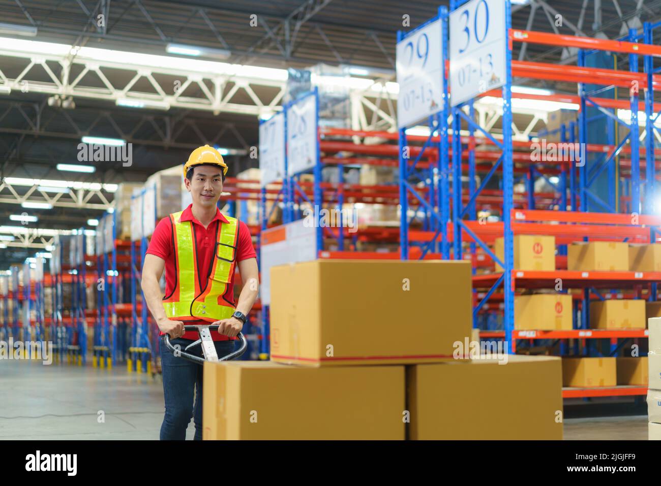 Shipping boxes. Asian man Warehouse worker unloading pallet shipment