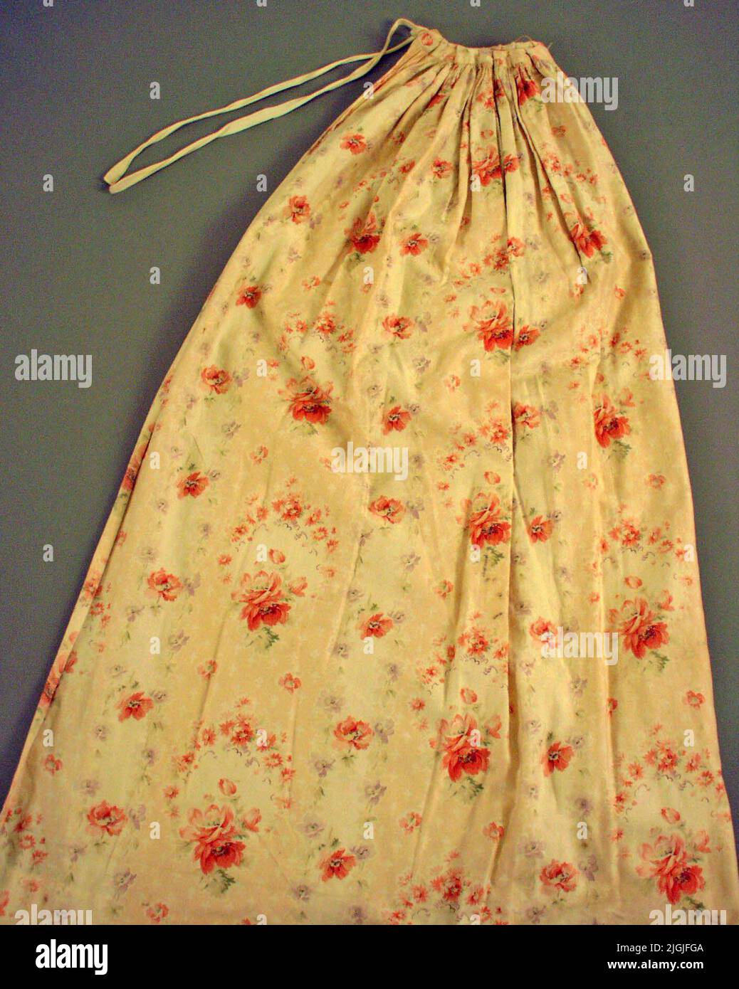 Förkläde Apron of cut -flowered cotton satin. Tightly wrinkled and later inmate with 6 folds on both sides. Partly hand and partly machine-sewn. The hem has previously been narrower. The apron consists of 2 rods. The tie bands are white four -shaft cotton straps. Stock Photo