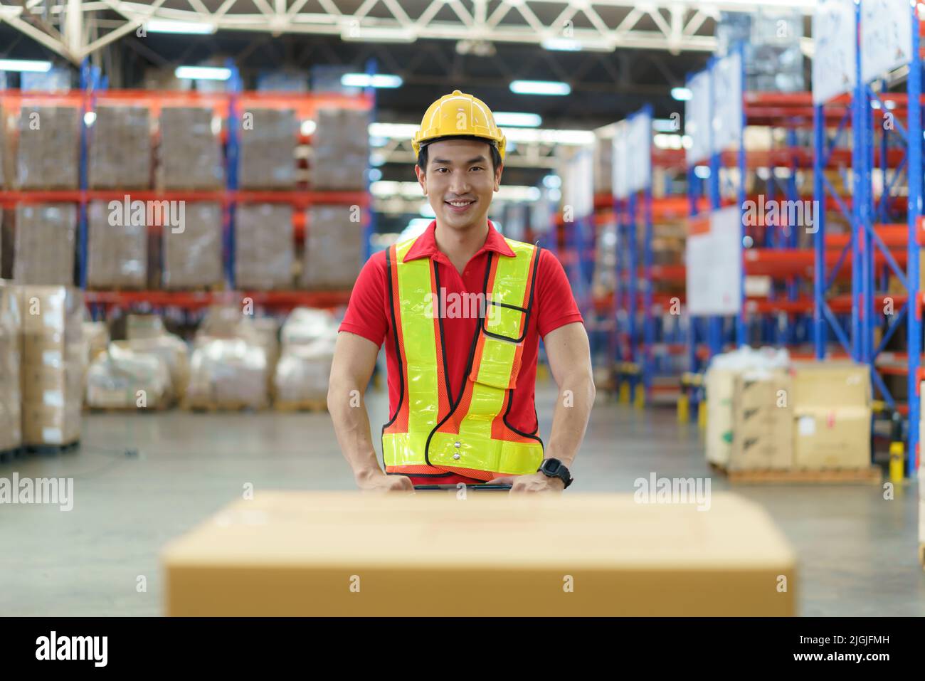 Asian man Warehouse worker unloading pallet shipment goods into a truck container, warehouse industry freight, logistics and transport. Stock Photo