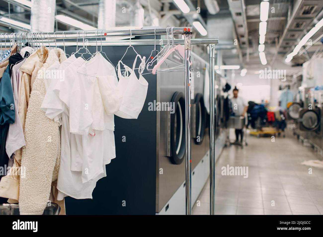 Dry cleaning clothes. Clean cloth chemical process. Laundry industrial dry-cleaning hanging clothes on rack Stock Photo