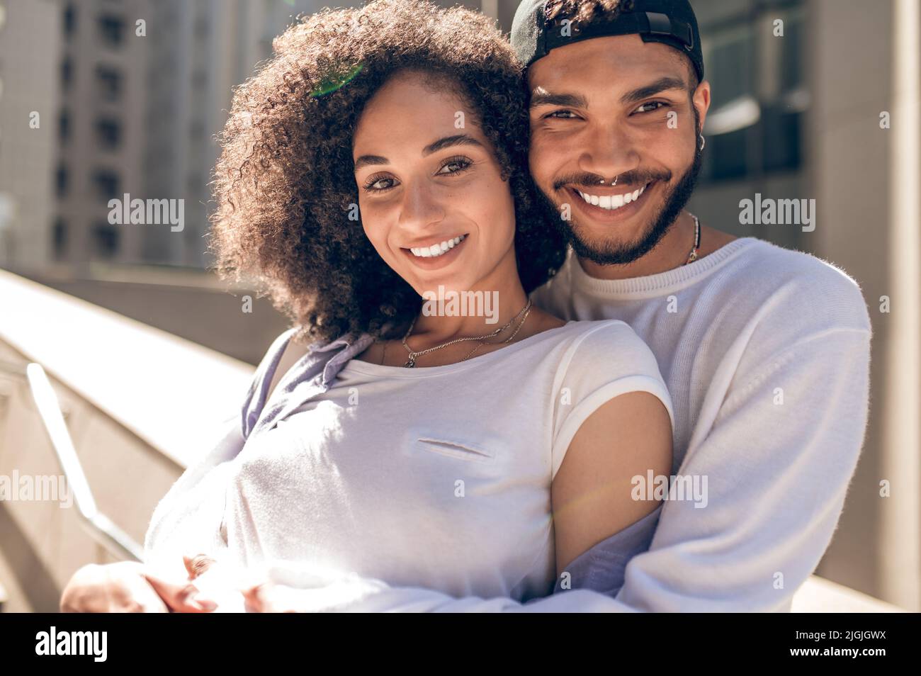 Lovely young couple in sunlight looking happy Stock Photo - Alamy