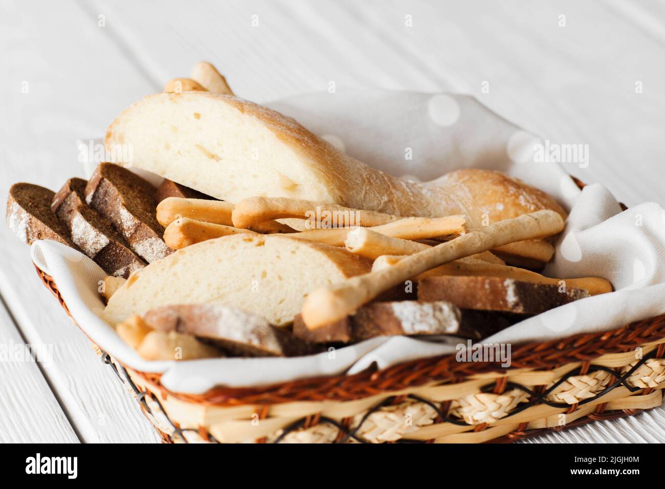 Dish with bread and breadsticks on white Stock Photo