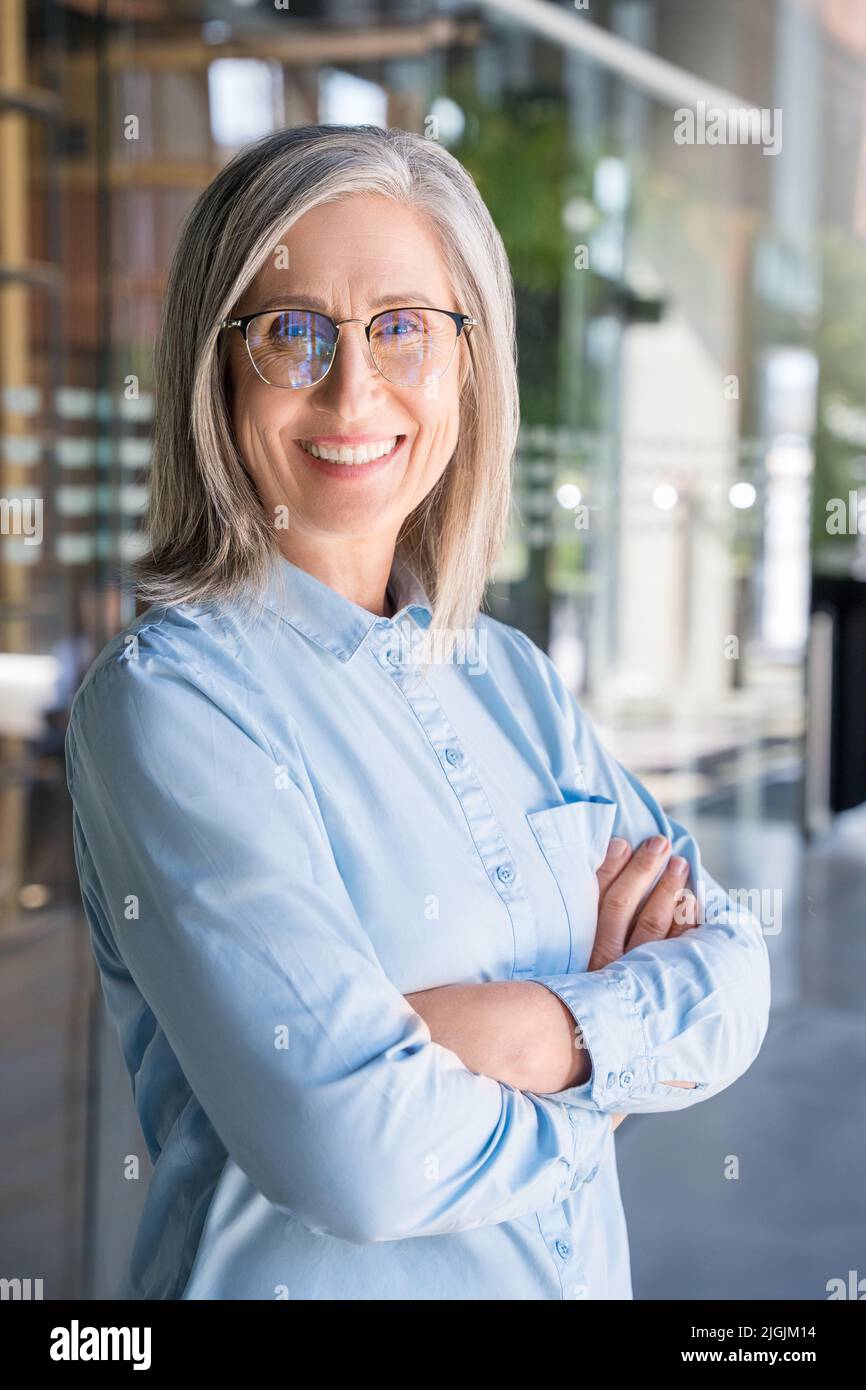 Verticasl portrait of smiling confident 60-s gray-haired mature woman. Stock Photo