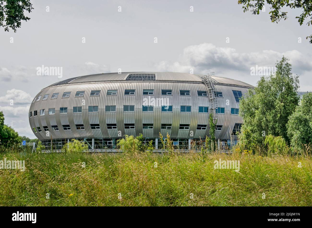 Almere, The Netherlands, July 6, 2022: remarkable, dome-shaped office building with shiny facade in a green environment Stock Photo