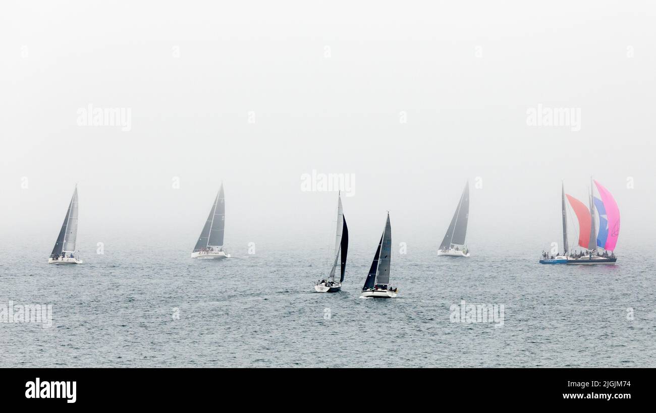 Crosshaven, Cork, Ireland. 11th July, 2022. With fog beginning to lift on the first day of Volvo Cork Week, yachts begin to race in full sail  outside Roches Point in Co. Cork, Ireland. - Credit; David Creedon / Alamy Live News Stock Photo