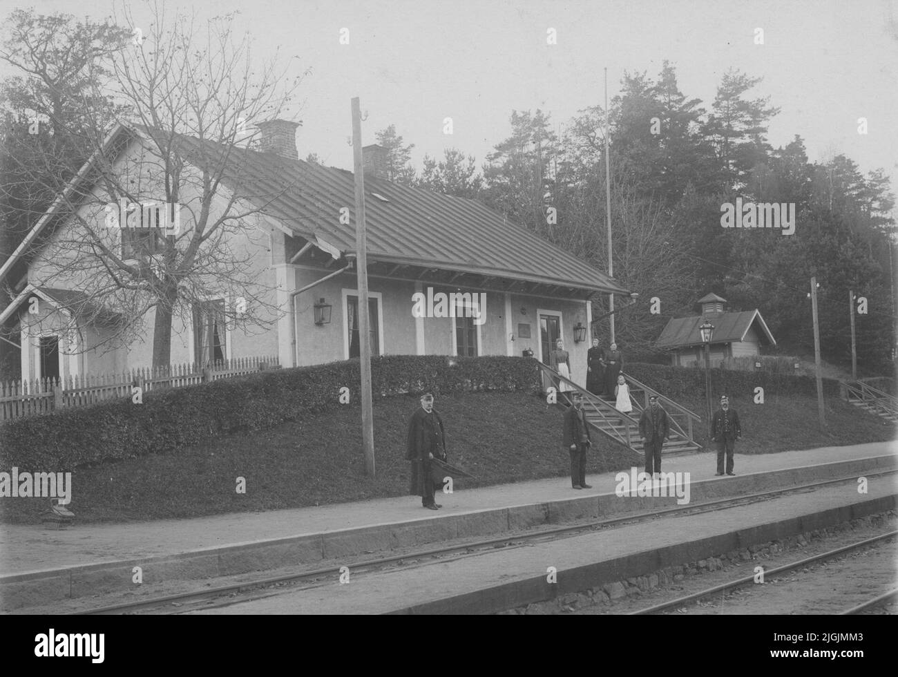 Järnvägsstation Rödeby railway station, surrounded by a hedge. Women ...
