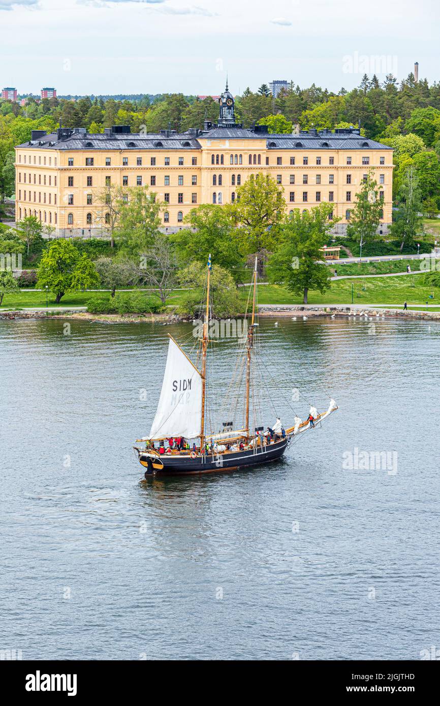 The sailing ship 'Ellen' passing Campus Manilla school on Djurgården Island into the Stockholm Archipelago, Sweden Stock Photo