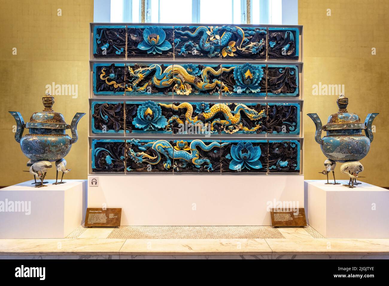 London, UK - 18th April 2022: Ming Dynasty glazed ceramic dragon tiles, dating from 15th to 16th century China, and two Cloisonne incense burners, Bri Stock Photo