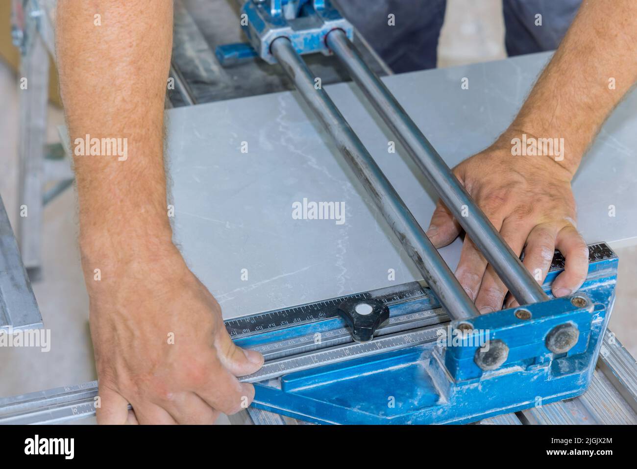 Construction worker on ceramic tile floor cutting the using manual
