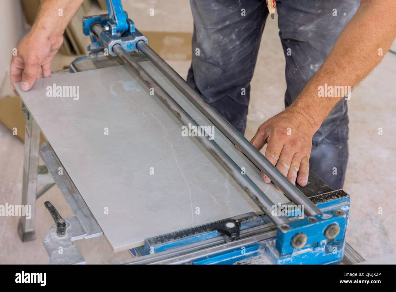 Using manual tools equipment, a construction worker cuts the ceramic tile using manual tools for laying ceramic tiles Stock Photo
